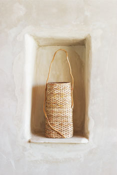 In a wall niche rests a beautiful turned basket made from natural materials by Joan Carrigan of Salt Spring Island, British Columbia. Opposite: A Turkish kilim covers the floor of Linda’s weaving room. Against the far wall sits her Schacht forty-inch floor loom on which she weaves functional fabrics, including blankets and lap robes. Above the loom hangs a Guatemalan huipil.